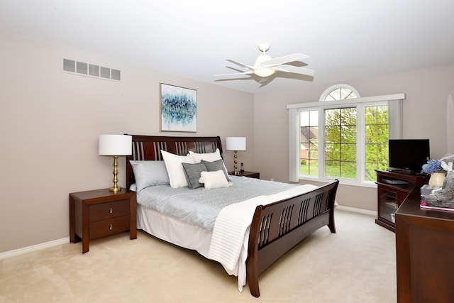bedroom with light colored carpet, baseboards, a ceiling fan, and visible vents