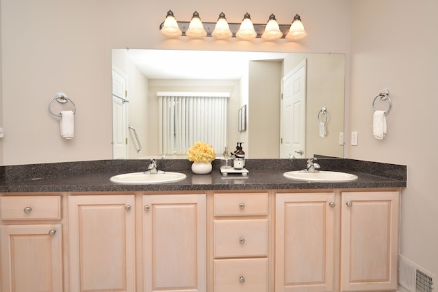 full bath featuring double vanity, visible vents, and a sink