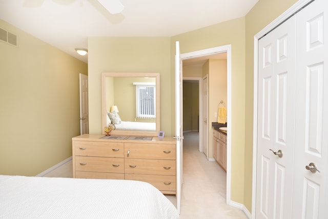 bedroom featuring light colored carpet, a closet, ceiling fan, and visible vents
