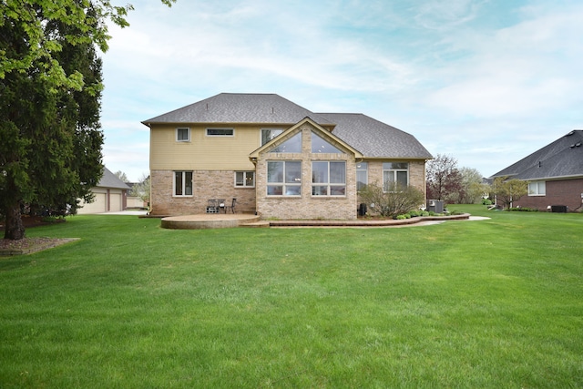 back of house featuring a patio area, roof with shingles, brick siding, and a lawn