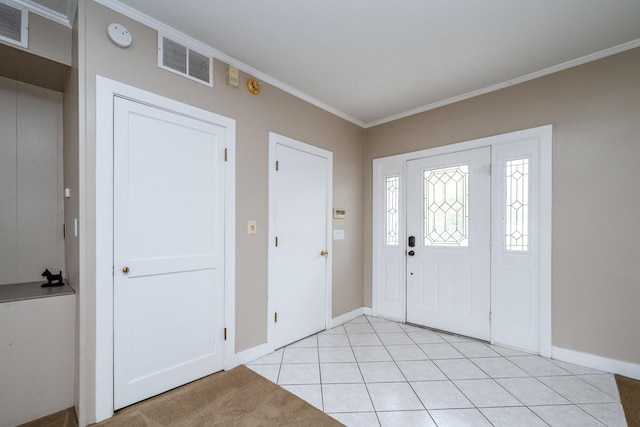 entrance foyer featuring baseboards, ornamental molding, light tile patterned floors, and visible vents