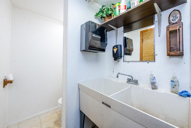 bathroom featuring toilet, baseboards, and vanity