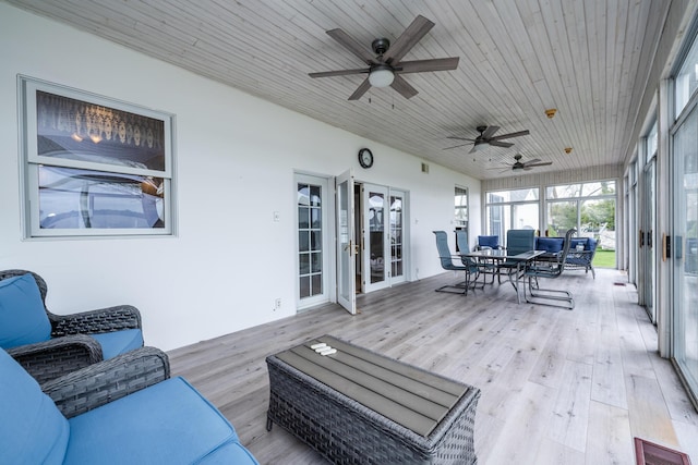 sunroom with outdoor dining space, a ceiling fan, and visible vents