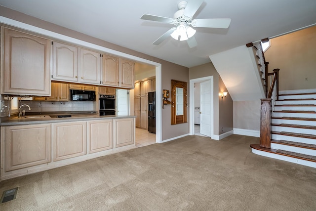 kitchen with a ceiling fan, visible vents, a peninsula, black appliances, and light colored carpet