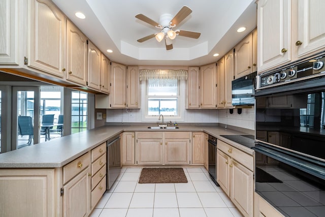kitchen featuring a sink, a peninsula, black appliances, ceiling fan, and light brown cabinetry