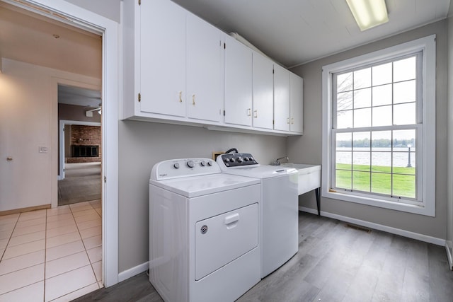 laundry room with cabinet space, separate washer and dryer, baseboards, and a ceiling fan