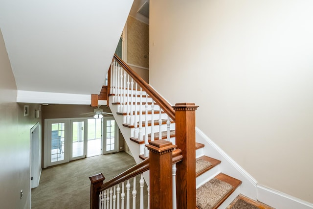 stairway with a high ceiling, baseboards, ceiling fan, and carpet floors