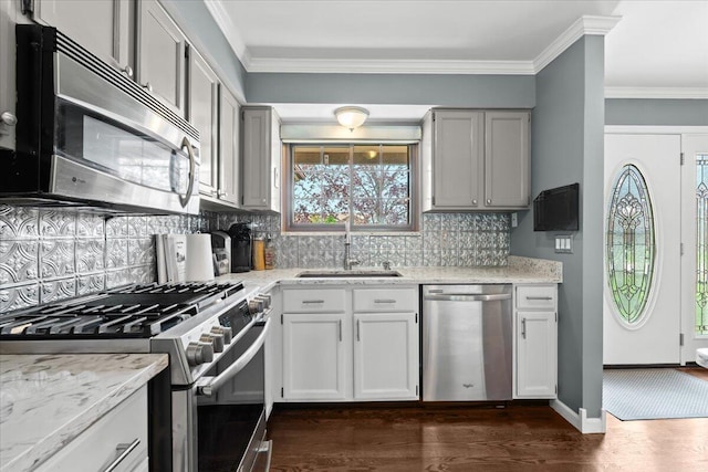 kitchen featuring appliances with stainless steel finishes, decorative backsplash, dark wood-style flooring, and a sink
