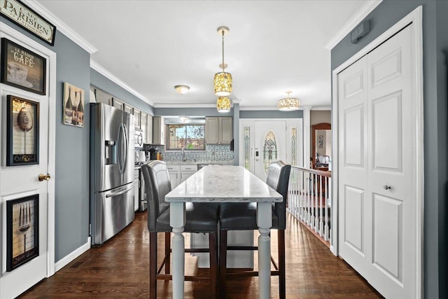 dining space with crown molding, dark wood-style flooring, and baseboards