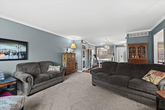carpeted living room with ornamental molding, baseboards, and visible vents