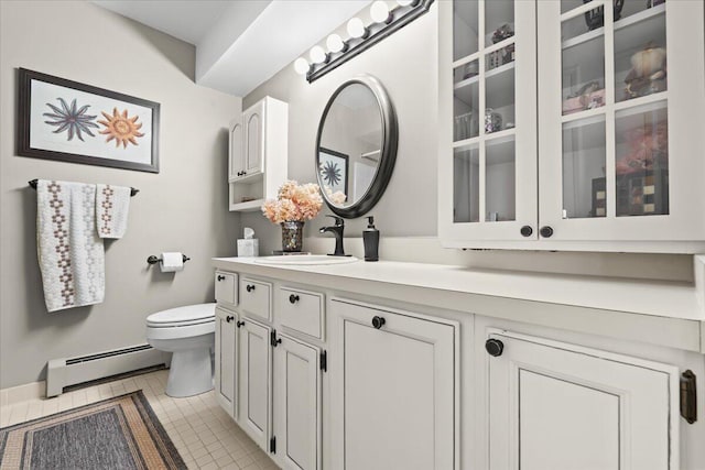 bathroom featuring toilet, tile patterned flooring, baseboard heating, and vanity