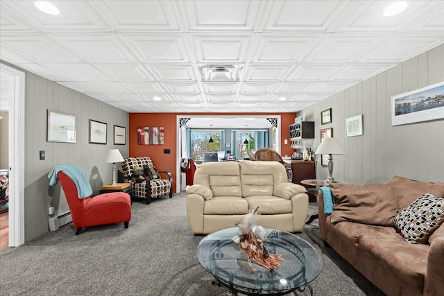 living area with carpet, wood walls, a baseboard heating unit, and an ornate ceiling