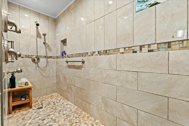 full bath featuring ornamental molding and tiled shower