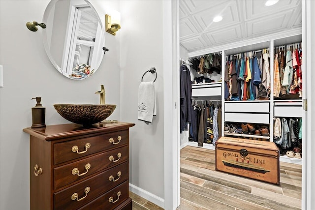 spacious closet with wood finished floors and a sink
