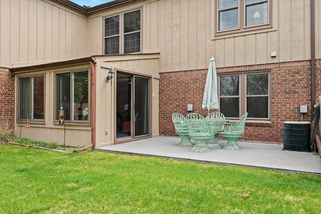 rear view of property with brick siding, a deck, and central AC unit