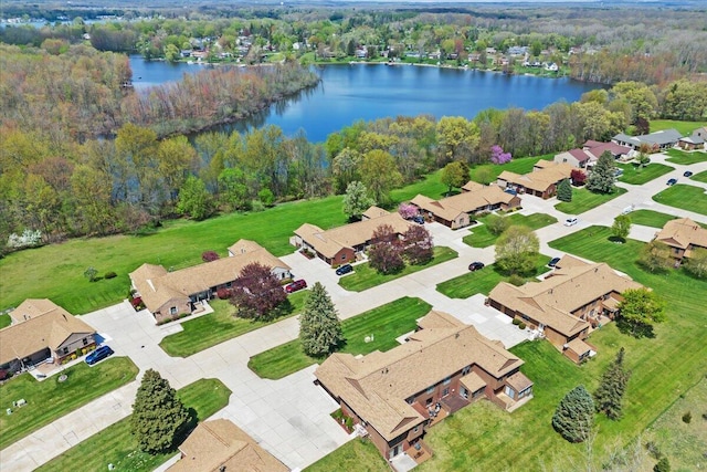 aerial view featuring a forest view, a water view, and a residential view