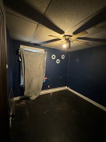 unfurnished room with baseboards, a drop ceiling, and ceiling fan