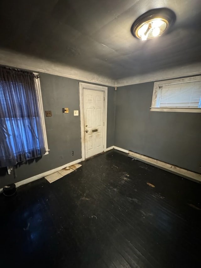 foyer entrance featuring baseboards and wood-type flooring