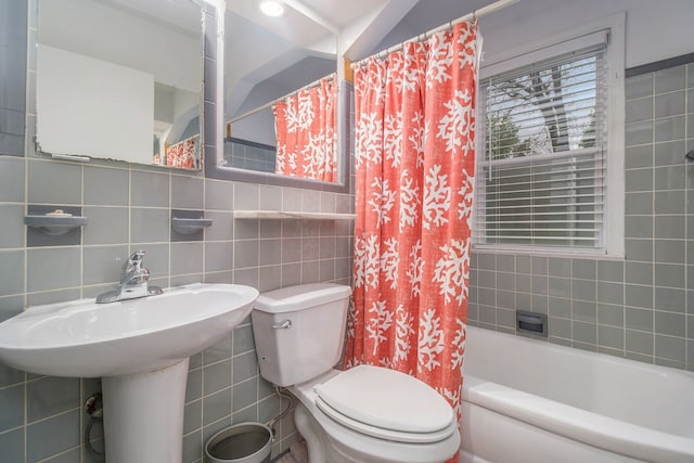 bathroom featuring tile walls, toilet, and shower / tub combo