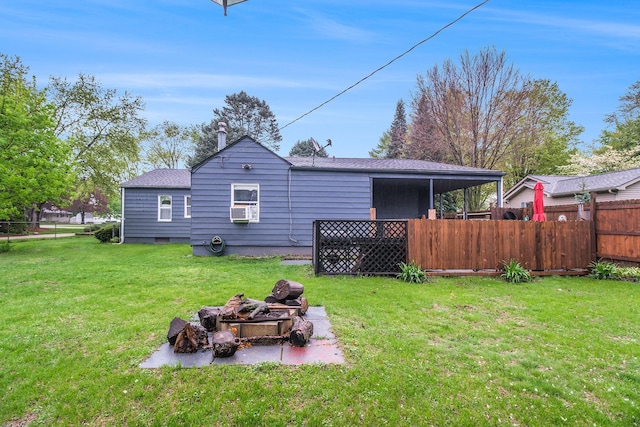 back of property featuring roof with shingles, fence, a fire pit, cooling unit, and a lawn