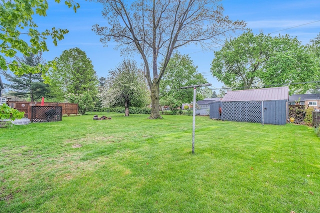 view of yard with an outbuilding, a shed, and fence