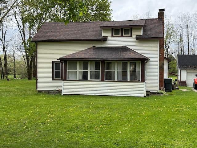rear view of house with a chimney, a yard, a shingled roof, a sunroom, and central AC