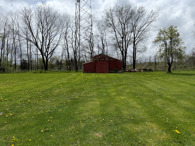 view of green lawn with an outdoor structure and a barn