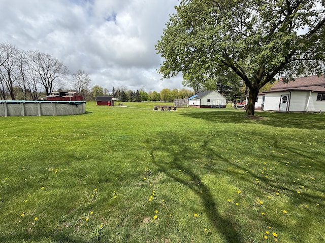 view of green lawn with an outdoor pool