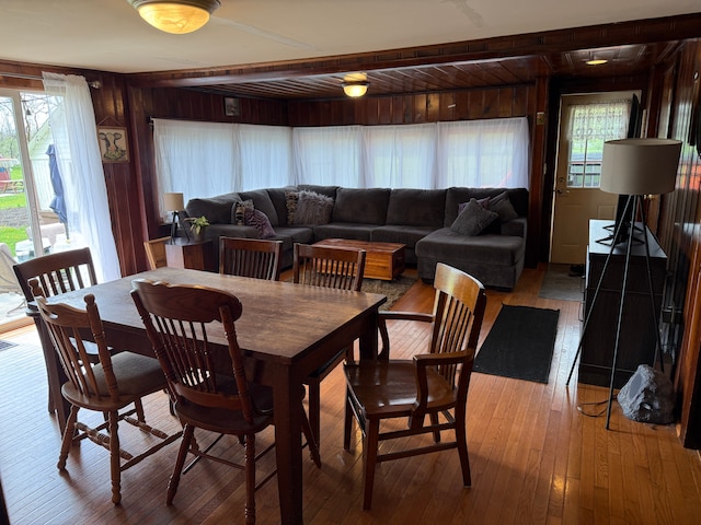 dining space featuring hardwood / wood-style floors and wood walls