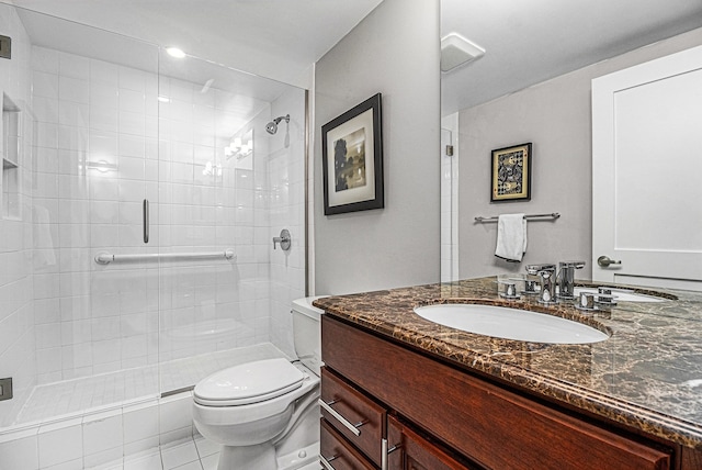 full bathroom featuring vanity, toilet, and a shower stall
