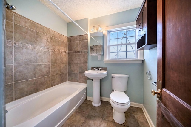 1009 S Webster St, Jackson, MI 49203 - bathroom featuring toilet, a textured ceiling, tile patterned flooring, and washtub / shower combination