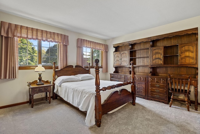 bedroom featuring light carpet and baseboards