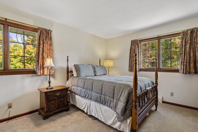 bedroom featuring light carpet and baseboards