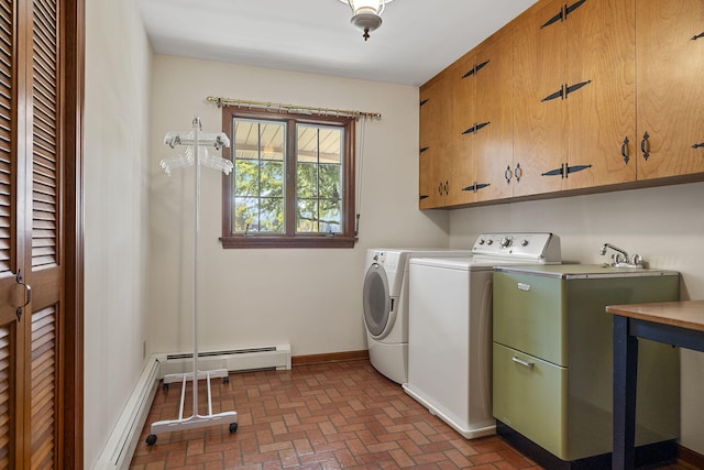 washroom with washer and dryer, cabinet space, baseboards, baseboard heating, and brick floor