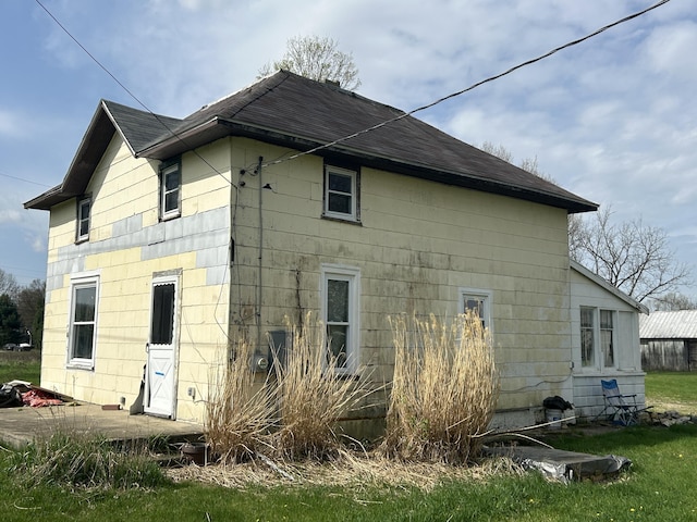 back of property with a shingled roof