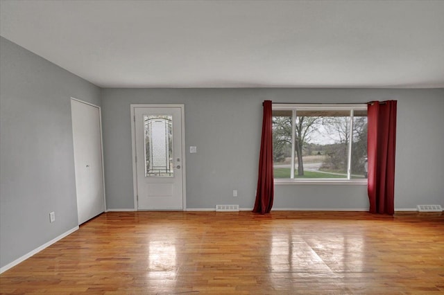 entrance foyer with baseboards, visible vents, and wood finished floors