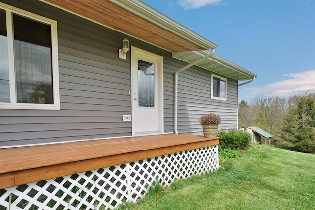 view of side of home featuring a wooden deck and a lawn