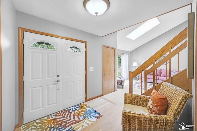 entrance foyer featuring a skylight, wood finished floors, and baseboards