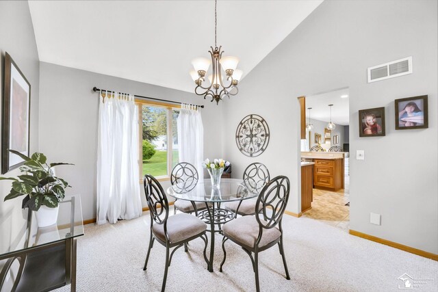 dining space with baseboards, an inviting chandelier, visible vents, and high vaulted ceiling