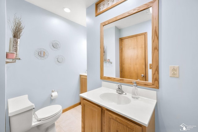 bathroom with toilet, vanity, and baseboards