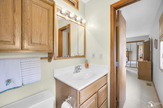 half bathroom featuring vanity, toilet, and visible vents