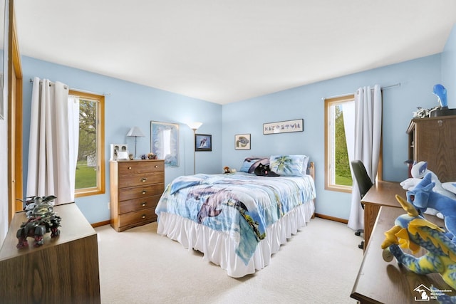 bedroom with light colored carpet, multiple windows, and baseboards