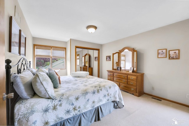 bedroom featuring light carpet, a closet, and baseboards