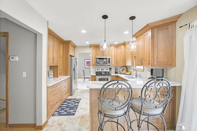 kitchen featuring stainless steel appliances, a sink, a peninsula, light countertops, and tasteful backsplash