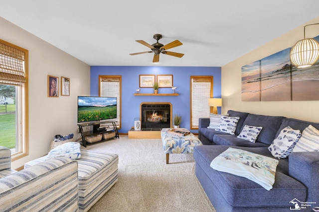 living room featuring carpet, a ceiling fan, and a glass covered fireplace