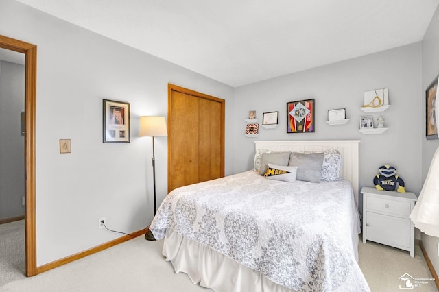 bedroom featuring light colored carpet, a closet, and baseboards