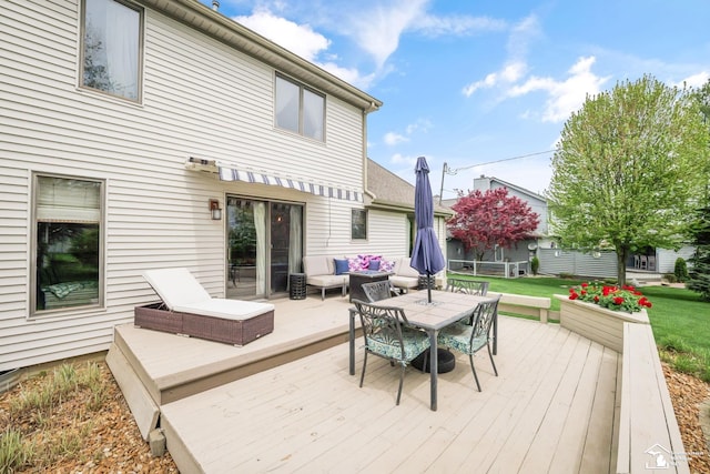 wooden terrace with outdoor lounge area and a lawn