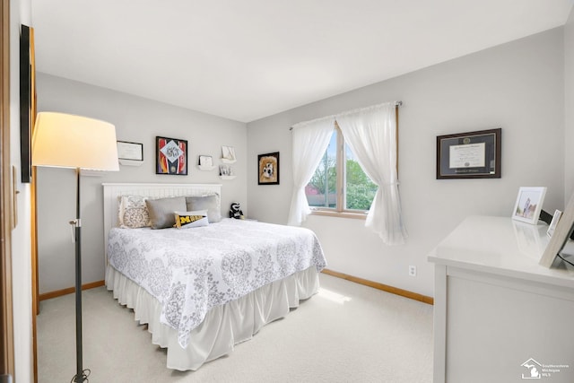 bedroom with light carpet and baseboards
