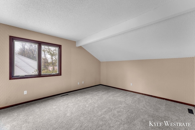 bonus room with vaulted ceiling with beams, carpet floors, a textured ceiling, visible vents, and baseboards