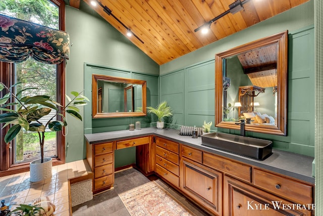 bathroom featuring wooden ceiling, vaulted ceiling, a decorative wall, and vanity
